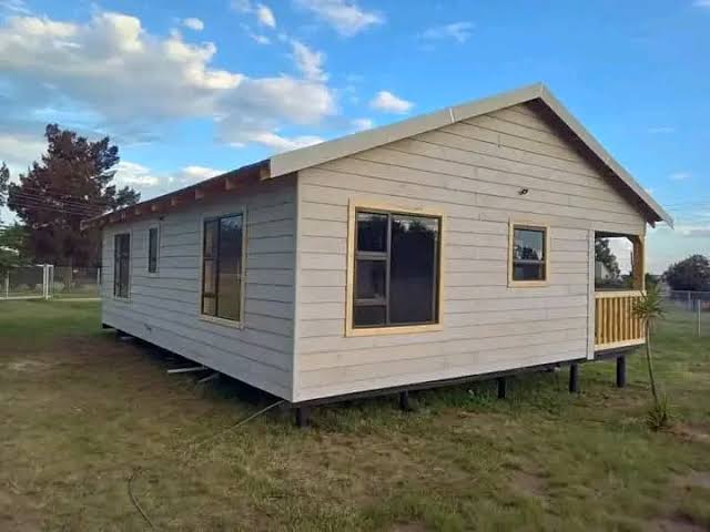Beige elevated house with deck in rural setting